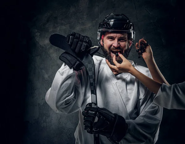 Mujer se alimenta jugador de hockey con uva —  Fotos de Stock