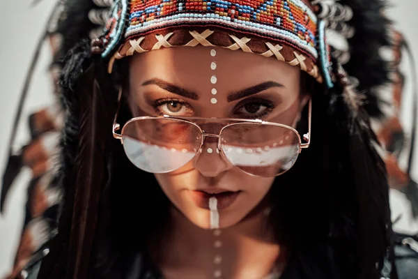 Foto da vicino di una ragazza alla moda con trucco tribale nativo americano in posa in uno studio — Foto Stock