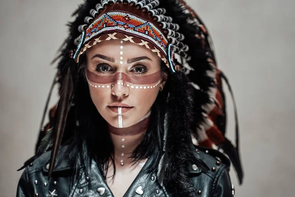 Native American female model wearing conceptual aztec chief headdress and tribal make-up in a studio — Stock Photo, Image