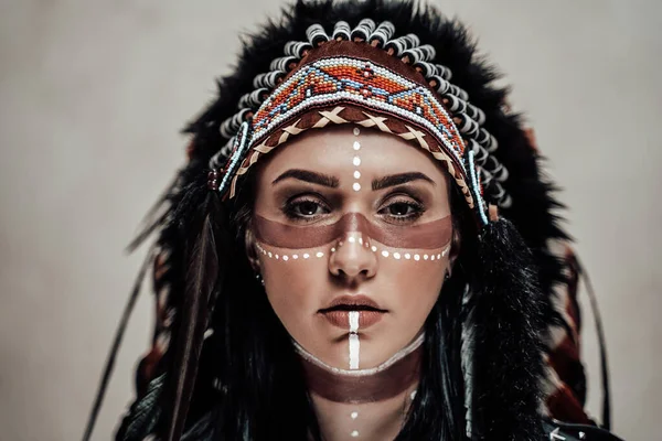 Modelo feminina nativa americana vestindo cabeça chefe azteca conceitual e maquiagem tribal em um estúdio — Fotografia de Stock