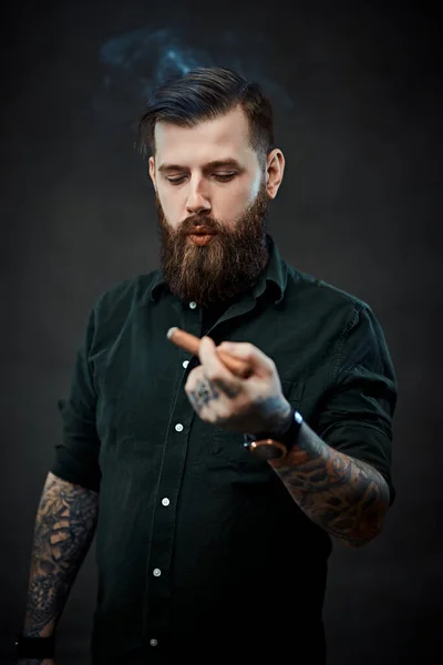 Stúdió portré egy jóképű tetovált hipszter fickóról, aki szivarozik. — Stock Fotó