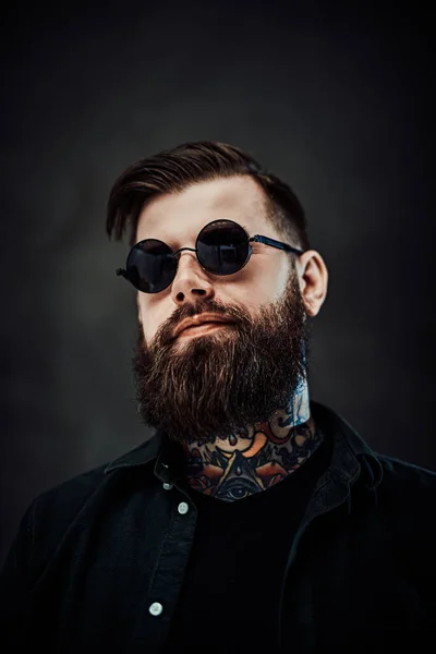 Portrait of a cool bearded male in sunglasses on a dark background — Stock Photo, Image