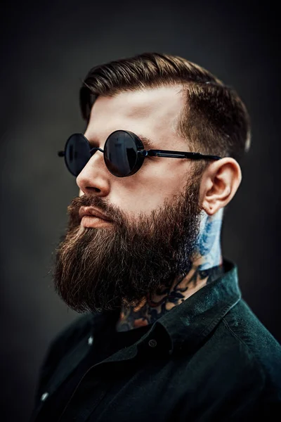 Portrait of a cool bearded male in sunglasses on a dark background — Stock Photo, Image