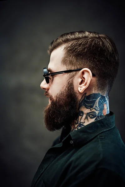 Portré egy hűvös szakállas férfi napszemüvegben egy sötét háttér — Stock Fotó