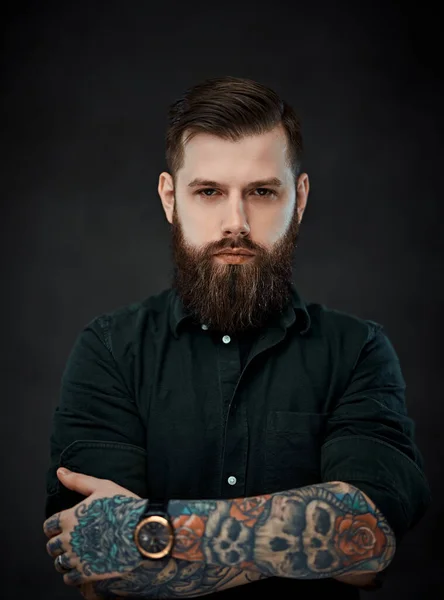 Красивый татуированный мужчина со стильной стрижкой, позирующий на тёмном фоне — стоковое фото