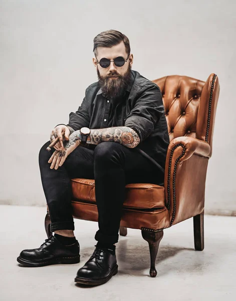 クールな髭を生やした若い男座っています上のAヴィンテージ椅子でAスタジオ — ストック写真