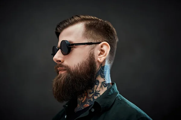 Portrait of a cool bearded male in sunglasses on a dark background — Stock Photo, Image