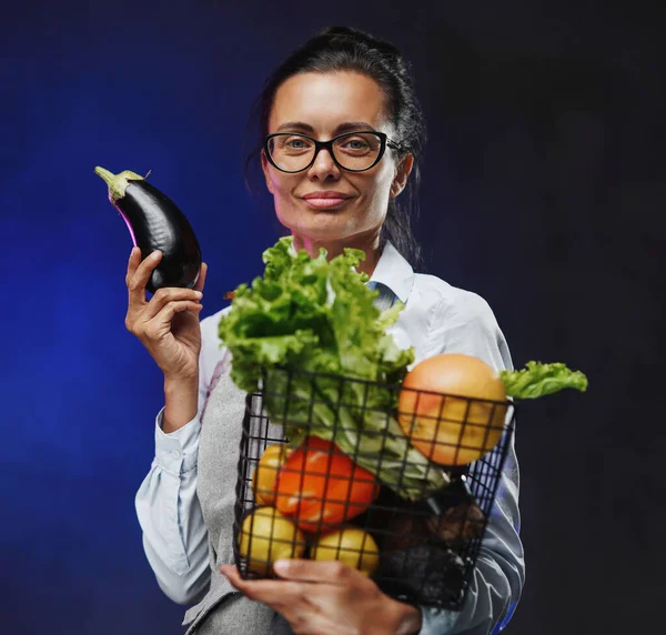 Ritratto di contadina di mezza età in grembiule regge un cesto di frutta e verdura fresca — Foto Stock