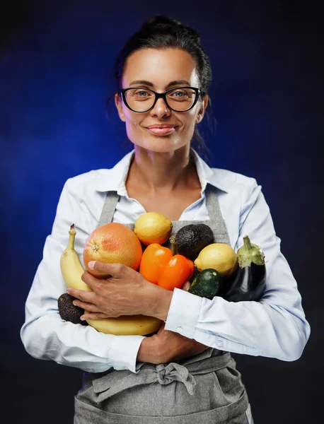 Egy gyönyörű középkorú nő portréja sok friss zöldséget és gyümölcsöt tartalmaz.. — Stock Fotó