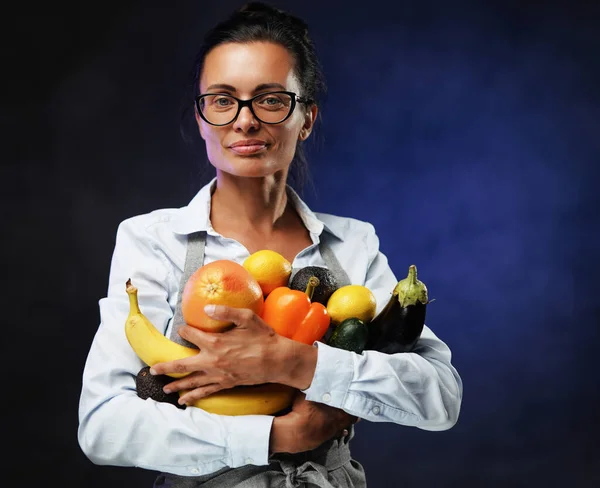 Portrait d'une belle femme d'âge moyen contient beaucoup de légumes et de fruits frais. — Photo