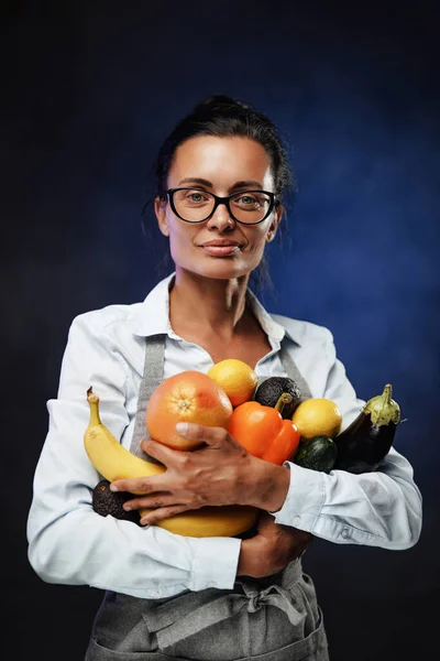 美しい中年女性の肖像画は新鮮な野菜や果物をたくさん持っています. — ストック写真
