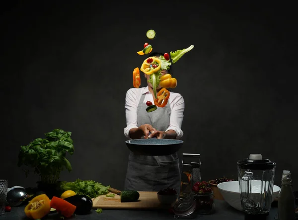 美しい成熟した女性キッチンで野菜サラダを調理し、パンから野菜をトス — ストック写真