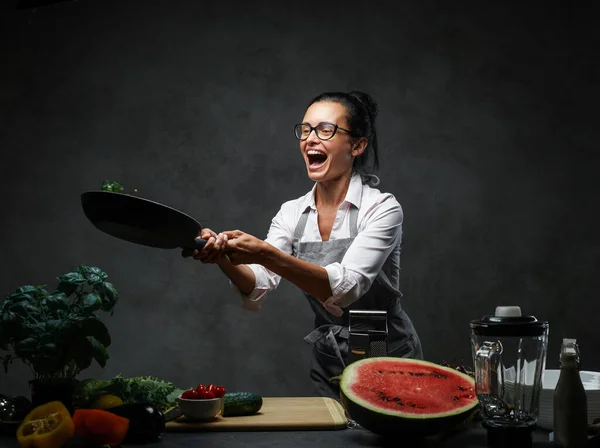 パンから野菜のみじん切りを投げる感情的な成熟した女性シェフ — ストック写真