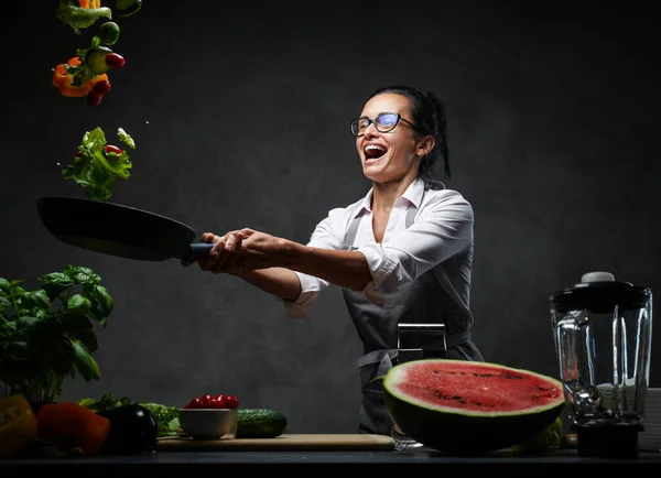 Duygusal olgun kadın aşçı tavadan doğranmış sebze atıyor. — Stok fotoğraf