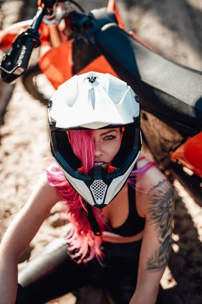 Menina hipster bonita com uma tatuagem em seu braço e cabelo rosa cobrindo o olho no capacete de segurança — Fotografia de Stock