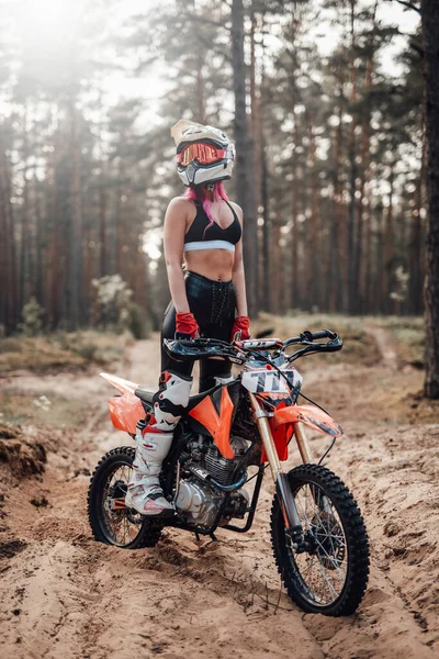 Giovane pilota di motocross femminile in casco di sicurezza in sella alla sua moto in avventura off road — Foto Stock