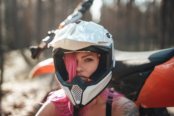 Schöne Hipster-Mädchen mit einer Tätowierung auf dem Arm und rosa Haare bedecken das Auge in Schutzhelm — Stockfoto