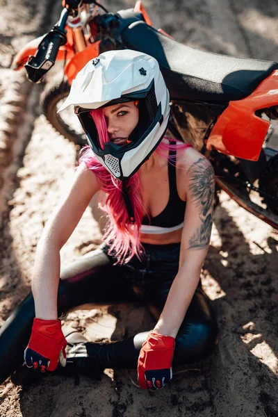 Hermosa chica hipster con un tatuaje en el brazo y el pelo rosa que cubre el ojo en casco de seguridad — Foto de Stock