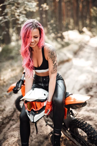 Ung racer flicka med rosa hår och tatuering på handen i sport behå sitter på en motorcykel — Stockfoto