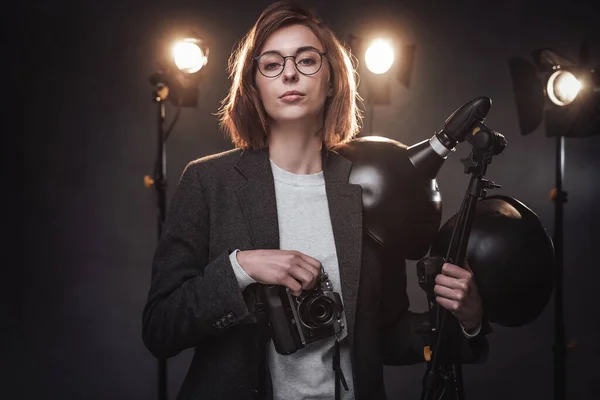 Linda fotógrafa ruiva tem uma câmera digital e olhando para a câmera — Fotografia de Stock