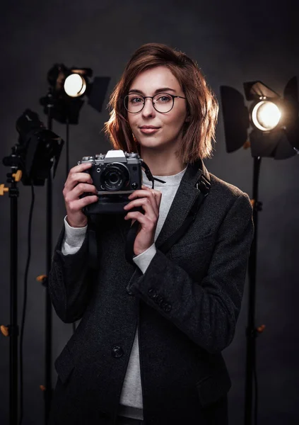 Güzel kızıl saçlı kadın fotoğrafçı elinde dijital kamerayla kameraya bakıyor. — Stok fotoğraf