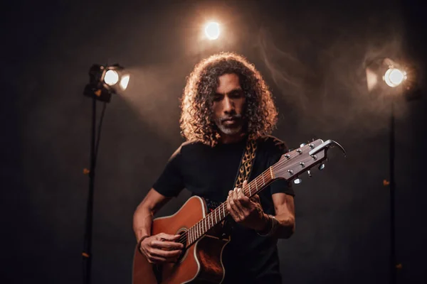 Talentoso músico hispânico tocando guitarra em luzes de palco — Fotografia de Stock