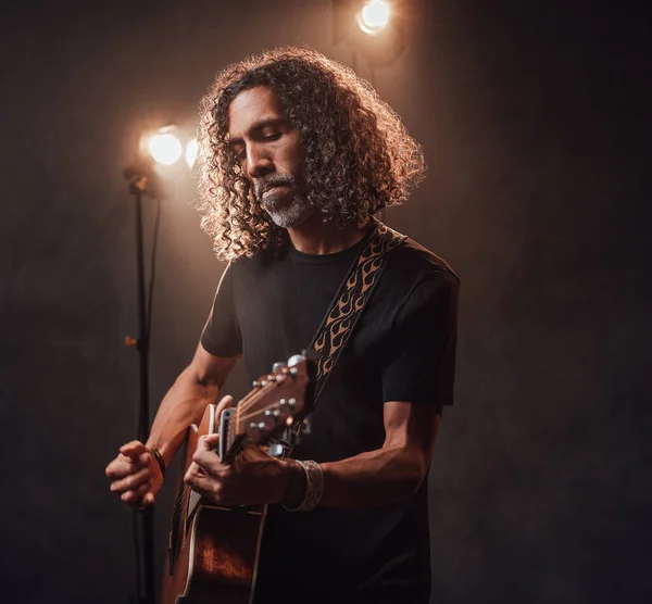 Talanted hispanic musician playing guitar in stage lights — Stock Photo, Image