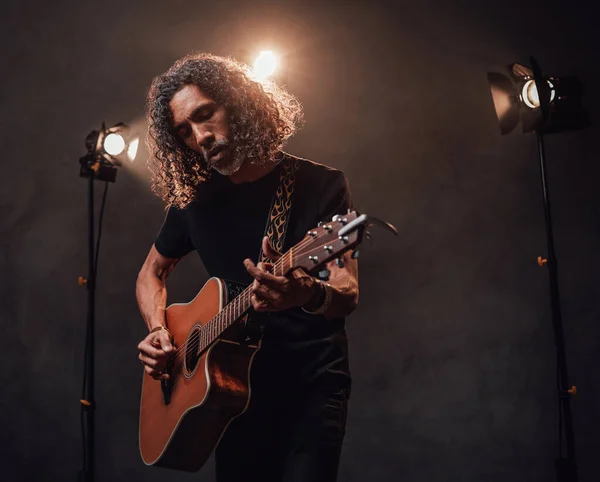 Talanted hispanic musician playing guitar in stage lights — Stock Photo, Image