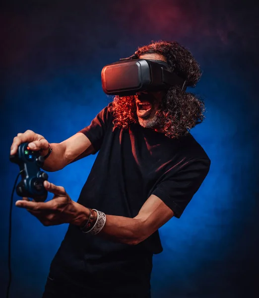 VR 안경을 끼고 조이스틱을 가지고 비디오 게임을 하고 있는 정서적 나이든 잠수 남자 — 스톡 사진