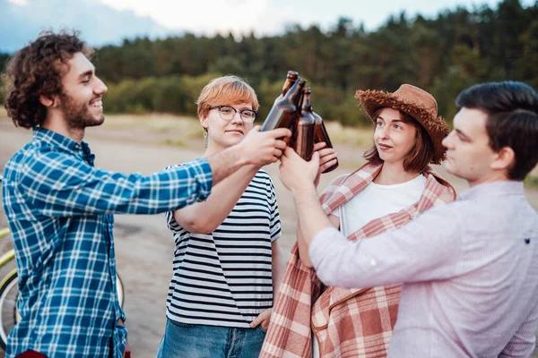Eine Gruppe alter Freunde verbringt ihre Freizeit am Strand und klirrt mit ihren Flaschen — Stockfoto