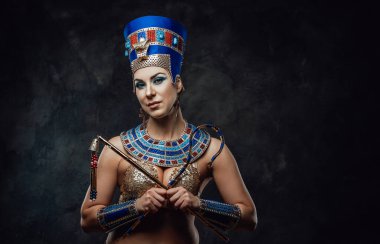 Mısırlı kostümlü olgun bir kadın. Stüdyoda poz veriyor.
