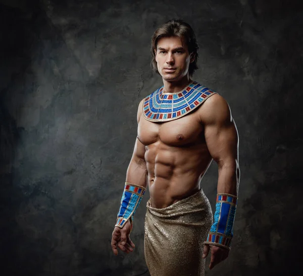 Stark och atletisk man i egyptisk kostym med blå armband — Stockfoto