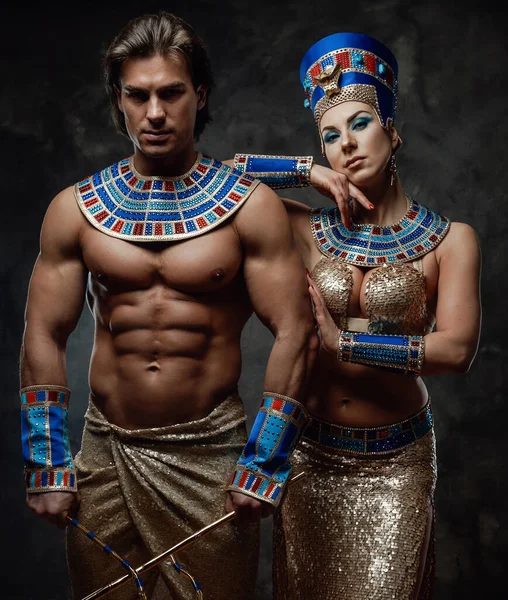 Two people in egyptian costumes, posing in the studio wit the dark background — Stock Photo, Image