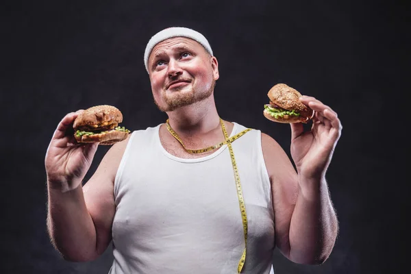 Grubas z dwoma hamburgerami w rękach — Zdjęcie stockowe