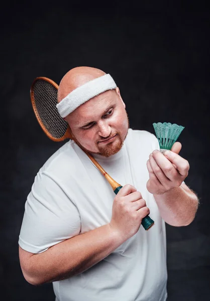 Un gordo calvo con una raqueta de bádminton en la mano mira el volante con una mirada estrecha — Foto de Stock