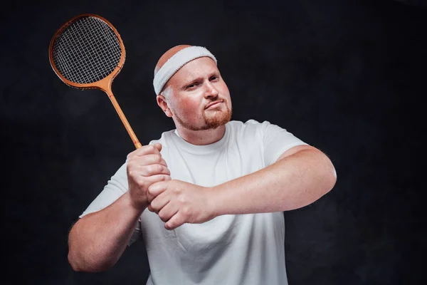 Un hombre en ropa deportiva blanca sostiene un cohete con dos manos, mirando a la cámara — Foto de Stock