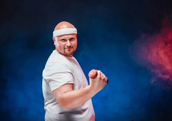 Tlustý muž na kontrastním červeno-modrém pozadí dělá cvičení s činky — Stock fotografie