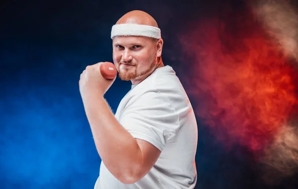 Pudgy man op een contrasterende rood-blauwe achtergrond doen oefeningen met halter — Stockfoto