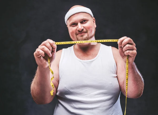 Zeer dikke man met een gele meetlint in zijn handen — Stockfoto