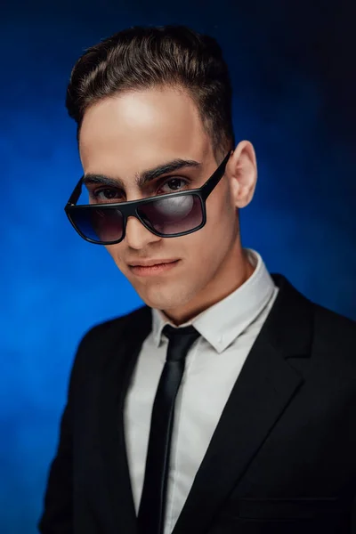 Guapo y exitoso. Retrato de un joven hombre de negocios con traje negro y gafas de sol — Foto de Stock