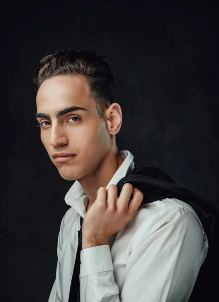 Portrait of a attractive young elegantly dressed man posing with jacket over his shoulder — Stock Photo, Image