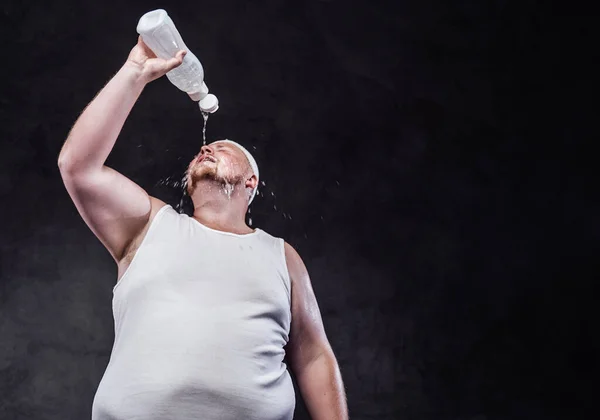 Dikke man giet water uit een fles op zijn gezicht — Stockfoto