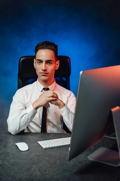 Young modern businessman in formalwear sits in the workplace, looking at the camera — Stock Photo, Image