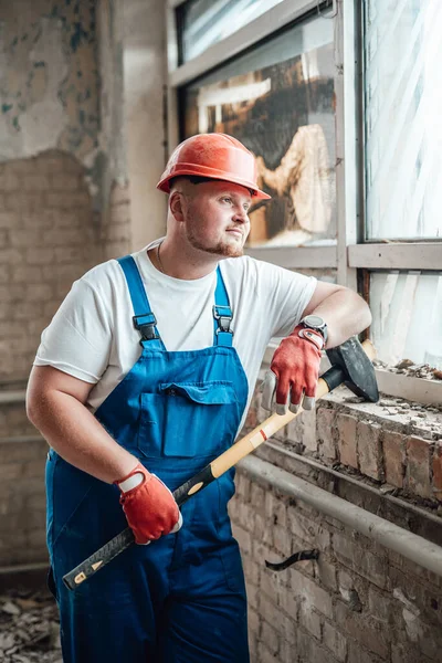 Very tired construction worker resting looking out of the window