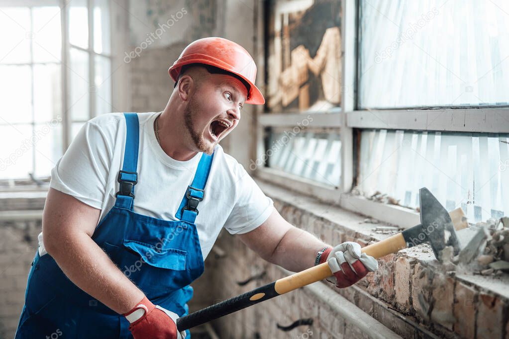 Builder at the construction site, smashing walls with a hammer, screaming