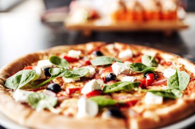 Peynirli, zeytinli ve otlu pizza.