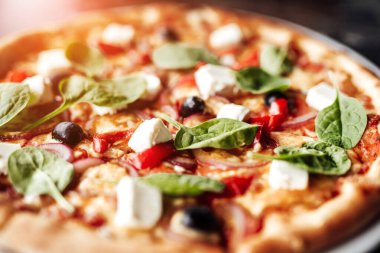 Peynirli, zeytinli ve otlu pizza.