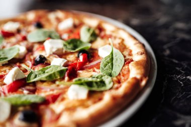 Peynirli, zeytinli ve otlu pizza.