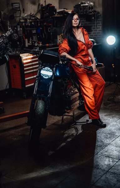 Sexy bruneta opírající se o černý motocykl — Stock fotografie