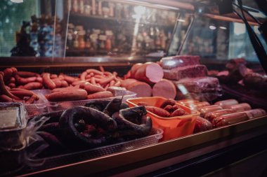 Siyah ve kahverengi sosislerle dolu bir market.